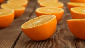 Halved oranges on a wooden surface.