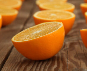 Halved oranges on a wooden surface.