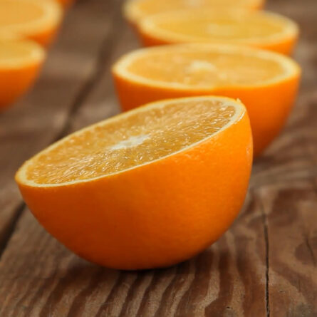 Halved oranges on a wooden surface.