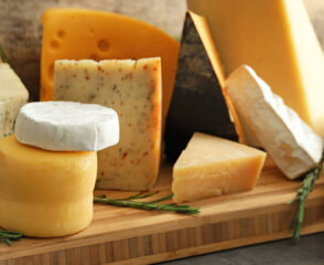 Assorted cheeses on a wooden board display.