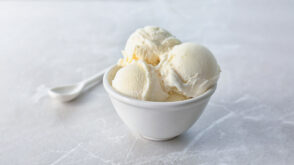 Bowl of vanilla ice cream with spoon.