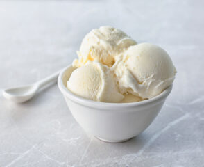Bowl of vanilla ice cream with spoon.