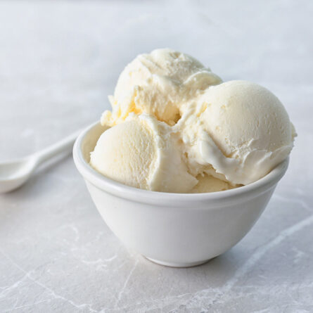 Bowl of vanilla ice cream with spoon.