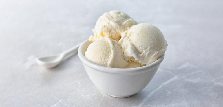 Bowl of vanilla ice cream with spoon.