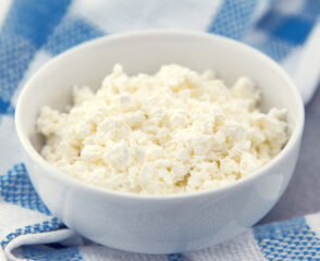 Bowl of cottage cheese on blue cloth.