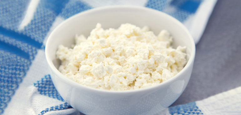 Bowl of cottage cheese on blue cloth.