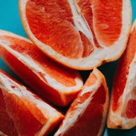 Sliced grapefruit on a blue plate.