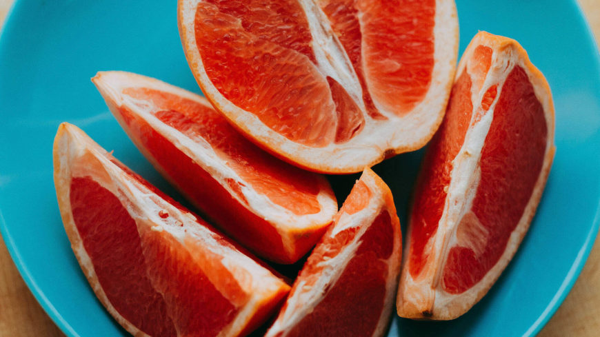 Sliced grapefruit on a blue plate.