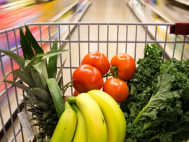Shopping cart with fruits and vegetables inside.