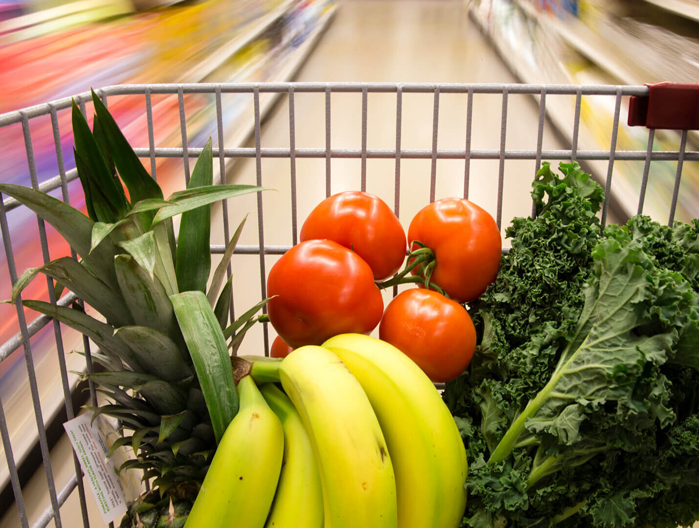 Shopping cart with fruits and vegetables inside.