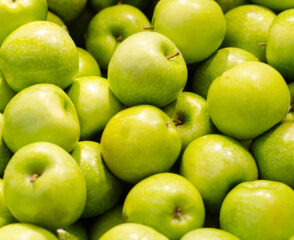 Pile of fresh green apples close-up.