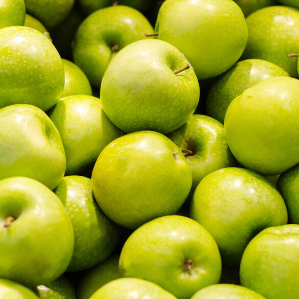Pile of fresh green apples close-up.