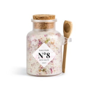 Glass jar of bath salts with spoon.