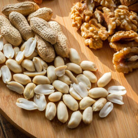 Assorted nuts on a wooden platter.
