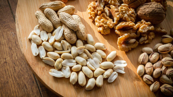 Assorted nuts on a wooden platter.