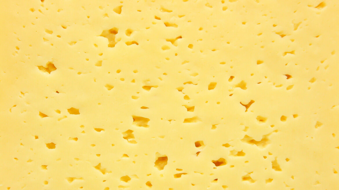 Assorted cheeses on a wooden board display.