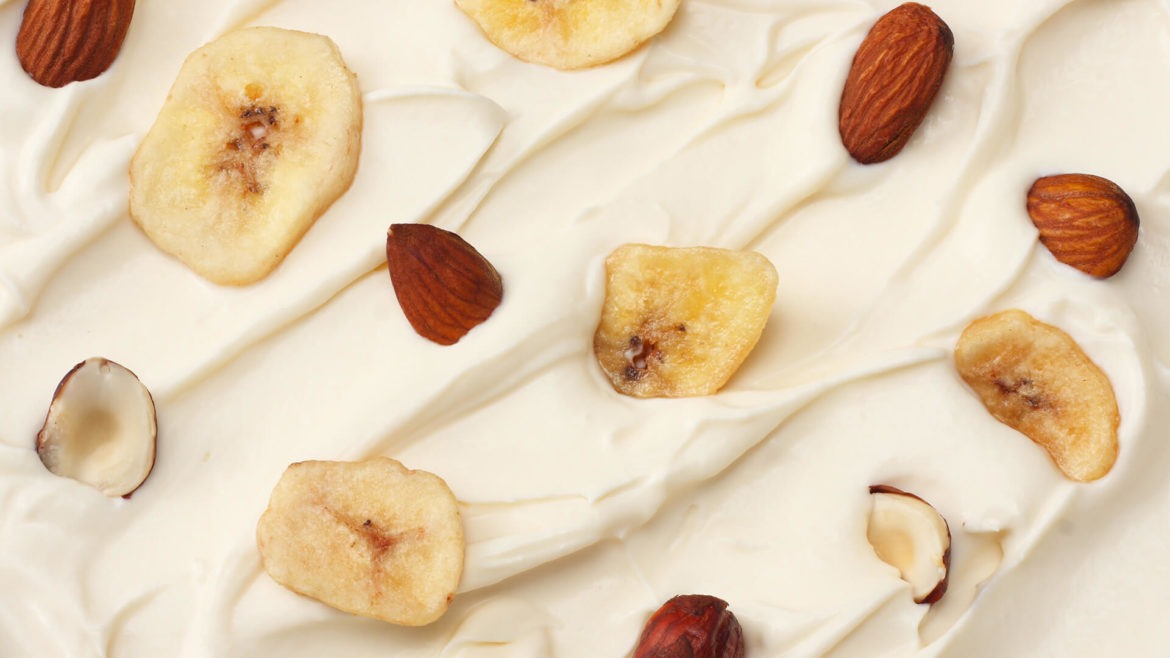 Yogurt topped with banana chips and nuts.